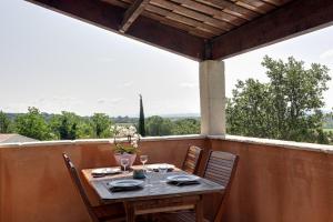 a table and chairs on a balcony with a view at Apartments La Vieille Source in Saint-Martin-dʼArdèche