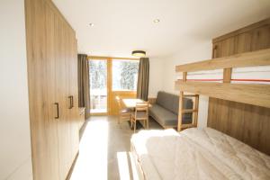 sypialnia z łóżkiem piętrowym i biurkiem w obiekcie Ferienwohnung 62 - Top 30 w mieście Königsleiten