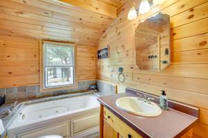 a bathroom with a tub and a sink at Lakefront Wisconsin Home - Deck, Fire Pit and Kayaks in Stone Lake +21 photos