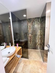La salle de bains est pourvue d'un lavabo et d'une douche. dans l'établissement Apartament Maria Novum Residence, à Olimp