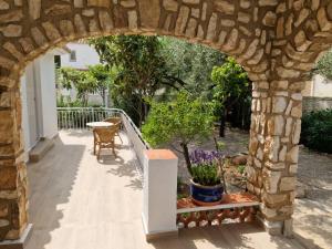 an archway over a patio with a table and flowers at Sunrise Villa Anya in Miami Platja