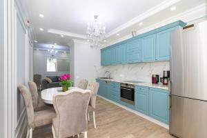 a kitchen with blue cabinets and a table and chairs at Premium Apartment Chisinau in Chişinău