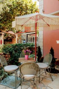 una mesa al aire libre con sillas y una sombrilla en PargaMondo Countryliving en Parga