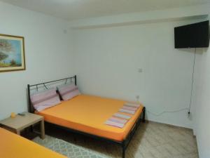 a bedroom with a bed and a flat screen tv at Apartmani Sofija in Nov Dojran