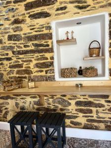 a stone wall with a bench and a mirror at Κυθνος Δρυοπίδα, Στούντιο Χατζής in Dhriopís +29 photos