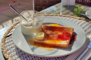 a white plate with toast and a glass of milk at Boutique Hotel Oriola in Cala de Sant Vicenc