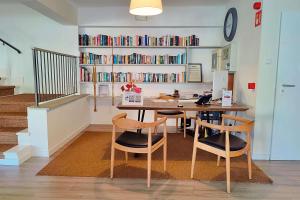a dining room with a table and chairs and a book shelf at Boutique Hotel Oriola in Cala de Sant Vicenc