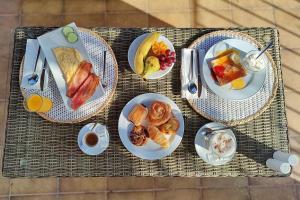 a table with plates of breakfast food on it at Boutique Hotel Oriola in Cala de Sant Vicenc