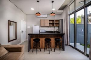 a kitchen with a counter and stools in a room at Top Studios Canasvieiras TPS in Florianópolis