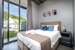 a bedroom with a bed and a large window at Top Studios Canasvieiras TPS in Florianópolis
