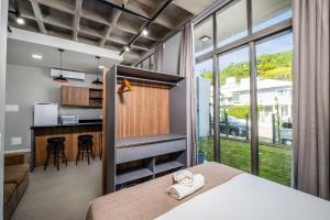 um quarto com uma cama e uma cozinha com um balcão em Top Studios Canasvieiras TPS em Florianópolis