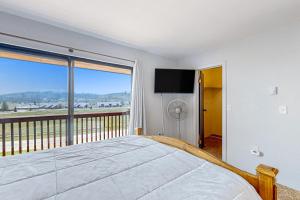 1 dormitorio con 1 cama y balcón con TV en Grand Lake Getaway, en Grand Lake