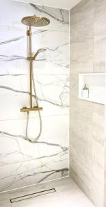 La salle de bains est pourvue d'une douche et de murs en marbre blanc. dans l'établissement Boutique appartment 4P with PRIVATE POOL, close by Jan Thiel & Mambo beach, à Willemstad