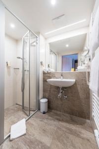 ein Bad mit einem Waschbecken und einer Dusche in der Unterkunft JUFA Hotel Grundlsee in Grundlsee