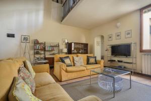 sala de estar con 2 sofás y TV en Charming Apartment in Oltrarno en Florencia
