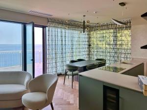 a kitchen with chairs and a view of the ocean at Maximilian Suites in Trieste