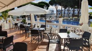 un restaurante con mesas y sillas y una piscina en Nice Duplex Home, Marbella, See View, Hotel Resort, en Marbella