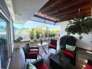 un soggiorno con sedie e tavolo con piante di Studios Don Bosco a Santo Domingo