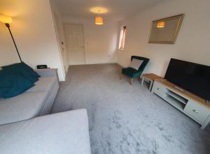 a living room with a couch and a flat screen tv at Swindon House by Cliftonvalley Apartments in Swindon