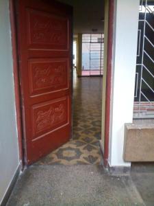 pasillo con puerta roja y suelo de baldosa en Alquilo 3 cuartos, 2 baños, patio, cocina, sala. Comas, en Lima