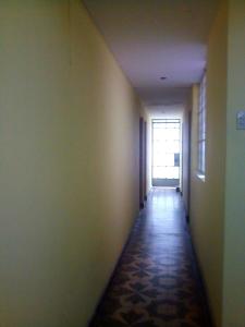 un pasillo vacío con un largo pasillo con una ventana en Alquilo 3 cuartos, 2 baños, patio, cocina, sala. Comas, en Lima