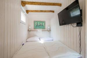 a small room with a bed and a tv at In Ons Tuintje - aan zee - Callantsoog in Callantsoog