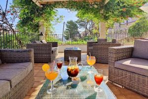 a glass table with wine glasses on a patio at Boutique Hotel Oriola in Cala de Sant Vicent