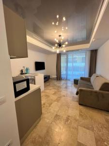 a living room with a couch and a tv at Apartament Maria Novum Residence in Olimp