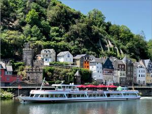 ein Boot im Wasser vor einer Stadt in der Unterkunft Burghaus-Cochem in Cochem