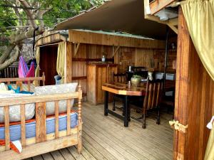 Scarborough Nature Lodge في كيب تاون: سطح خشبي مع طاولة وغرفة طعام
