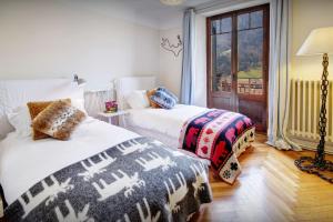 a bedroom with two beds and a window at Manoir de Leschaux - OVO Network in Le Petit-Bornand-lès-Glières