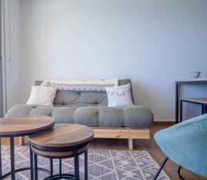 ein Wohnzimmer mit einem Sofa und 2 Tischen in der Unterkunft Cosy and modern studio with view - Huez - Welkeys in Huez