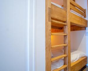 Etagenbett in einem kleinen Zimmer mit Holzregalen in der Unterkunft Cosy and modern studio with view - Huez - Welkeys in Huez