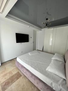 a bedroom with a bed and a tv on the wall at Apartament Maria Novum Residence in Olimp