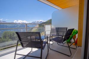 2 Stühle und ein Tisch auf einem Balkon mit Aussicht in der Unterkunft Cosy and modern studio with view - Huez - Welkeys in Huez