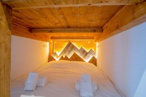 Bett in einem Zimmer mit Holzdecke in der Unterkunft Cosy and modern studio with view - Huez - Welkeys in Huez