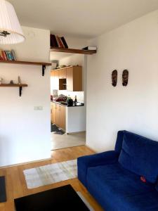 a living room with a blue couch and a kitchen at Blerta's apartment in Prizren