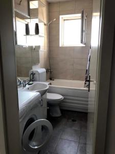 a bathroom with a sink and a toilet and a tub at Blerta's apartment in Prizren
