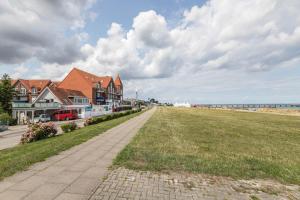 a sidewalk next to a beach with houses and the ocean at Treibholz - Feriendomizil Ostsee in Schönberger Strand