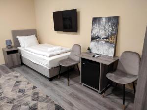 a bedroom with a bed and two chairs and a desk at Villa Grácia in Badacsonytomaj