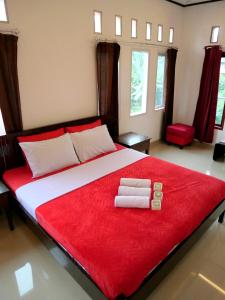 ein Schlafzimmer mit einem großen Bett mit zwei Handtüchern darauf in der Unterkunft The Sanduk Homestay in Rantepao