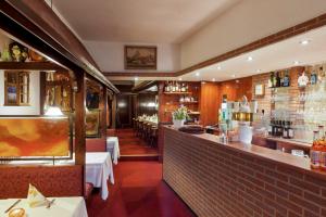 a restaurant with a bar with tables and chairs at Restaurant Donau in Hannover