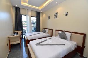 a hotel room with two beds and a chair at Supreme Villa in Kigali