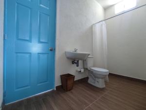 uma casa de banho com uma porta azul e um WC em Finca Mar de Leva em Santa Marta