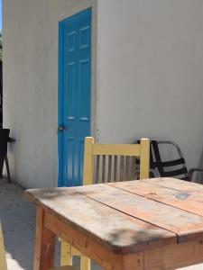 a wooden table with a blue door in front of a building at Finca Mar de Leva in Santa Marta