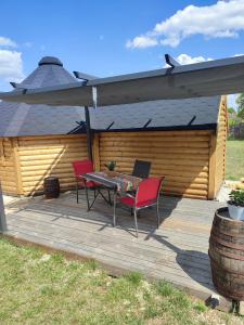a patio with a table and chairs on a deck at Le kota des 3 tilleuls in Dampierre-sur-Salon
