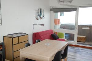 a living room with a table and a red couch at Vue mer les Becs Saint Hilaire in Saint-Hilaire-de-Riez +9 photos