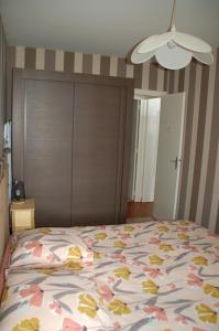 a bedroom with a bed with a floral bedspread at Vue mer les Becs Saint Hilaire in Saint-Hilaire-de-Riez