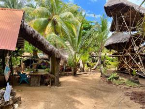 a resort with palm trees and a straw hut at Ensueños big rooms in Little Corn Island