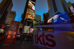 a city street with tall buildings and a kiss sign at Hotel Edison Times Square in New York +37 photos